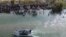 Un barco de la Patrulla Fronteriza de EEUU pasando a un gran grupo de migrantes que esperan cruzar la barrera de alambre de púas hacia los Estados Unidos, en Eagle Pass, Texas, el 25 de septiembre de 2023.