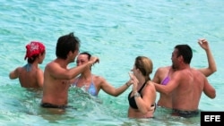 Grupo de turistas bailando en una playa de La Habana (Cuba).