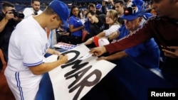 Omar Vizquel firma autógrafos tras finalizar el partido con los Mellizos de Minnesota en octubre de 2012.