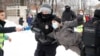 Un hombre vestido con un chaleco de prensa sostiene un micrófono mientras la policía lo detiene durante una manifestación en apoyo a Aleksei Navalny en San Petersburgo el 31 de enero de 2021.