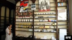 Una dependienta habla por teléfono frente a un estante de una Farmacia.