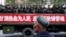 Un hombre uigur observa un camión que transporta policías paramilitares durante un mitin de juramento antiterrorista en Urumqi, Región Autónoma Uigur de Xinjiang, en 2014. (Reuters).