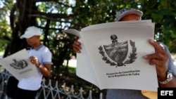 Dos personas leen el Proyecto de Constitución que el régimen de La Habana somete a "debate" público.