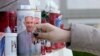 Una mujer deja un rosario junto a velas adornadas con la imagen del papa Francisco, en el exterior del hospital Agostino Gemelli de Roma. (AP/Gregorio Borgia)