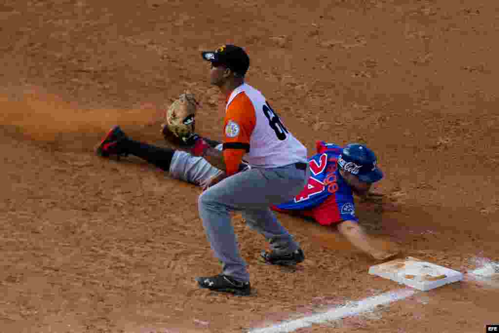 Ramon Lunar (i), de Villa Clara de Cuba, intercepta una pelota en primera base ante Juan Perez (d) de Tigres del Licey de República Dominicana hoy, lunes 3 de febrero de 2014, durante el tercer día de la Serie del Caribe 2014, en el Estadio Nueva Esparta, en Margarita (Venezuela). 